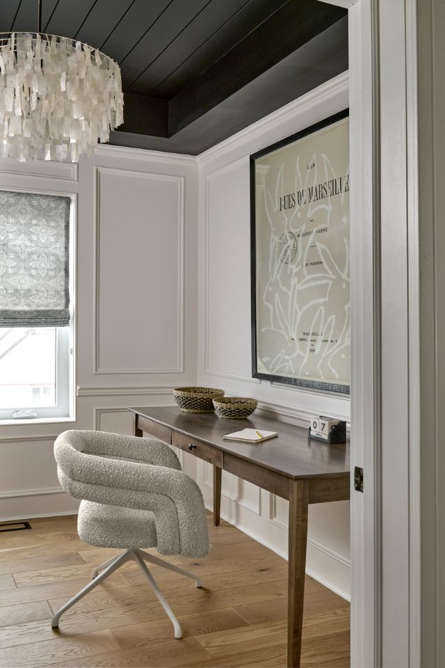 simple home office with statement lighting and hardwood floors